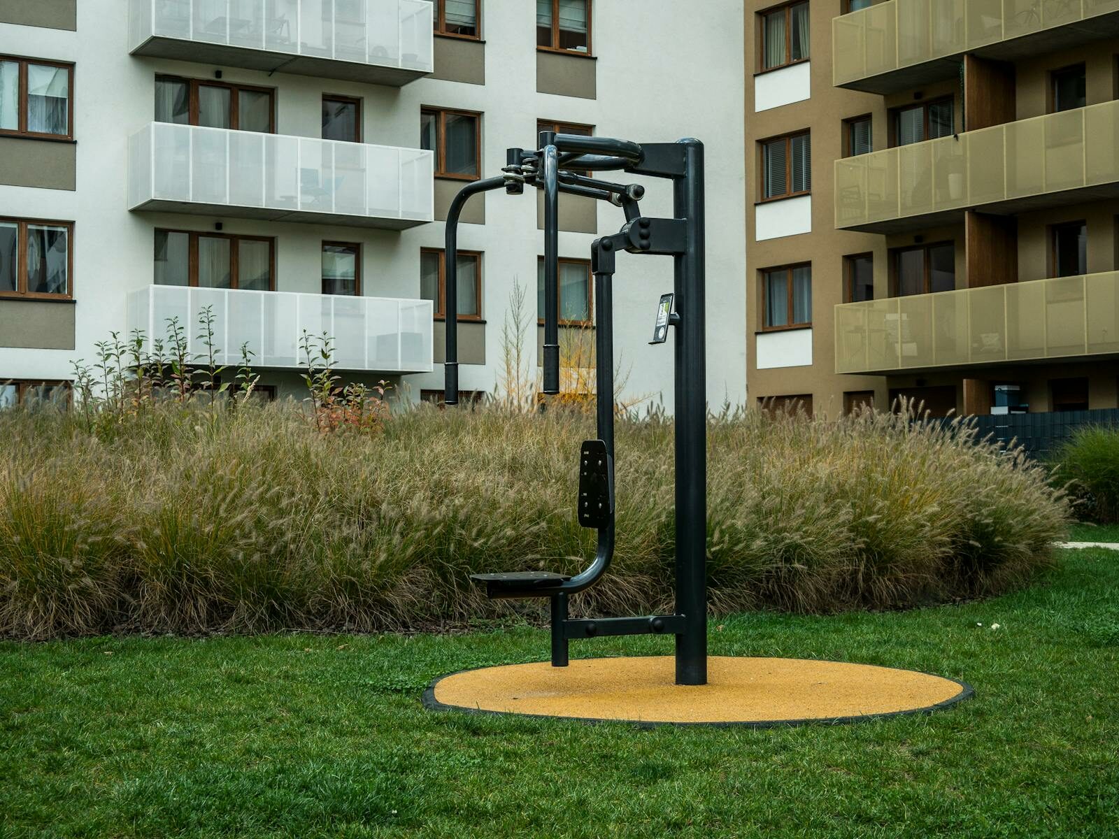 Outdoor exercise equipment in a residential area with modern apartments.